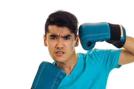 生气的黑发拳击手运动员在蓝色的手套，看着相机孤立在白色背景上的肖像