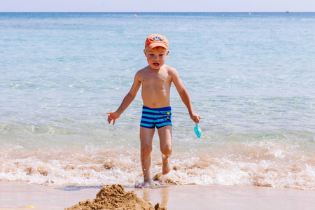 男孩在沙滩和海浪中玩耍