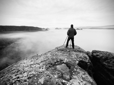 艺术家摄影师的作品与三脚架上悬崖以上的云。梦幻守旧景观
