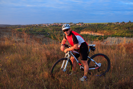 年轻成人自行车骑山地自行车在农村照片