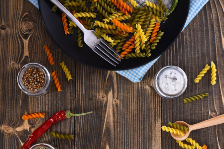 干螺丝面食和叉在黑版上蓝色的桌布