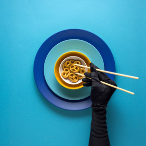 创意概念照片的厨具与手, 漆板上的食物在蓝色背景