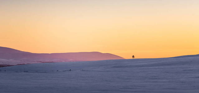 挪威中部一个美丽多彩的冬季日落。温暖的黄昏照亮了群山