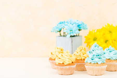 黄色和蓝色菊花在破旧别致的花瓶与蛋糕装饰与招标奶油。Copyscape 地区