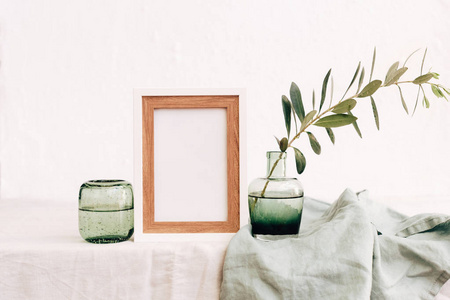 在花瓶里用橄榄树枝在亚麻桌布上模仿。最小生态概念