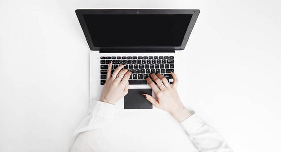 商业妇女使用模拟笔记本电脑与笔记簿在白色办公桌上
