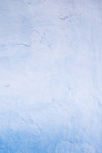 土坯墙用白色和蓝色的石灰粉刷, 痕迹的刷子, 裂缝, 质地和浮雕, 垂直纹理的设计背景。乌克兰