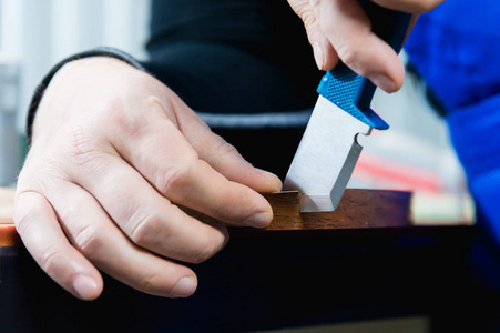 木匠没有精心打扮的手完成的纸板细节的家具通过切断边缘的剥离装饰条