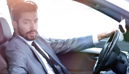在他的车的司机座位的英俊商人图片