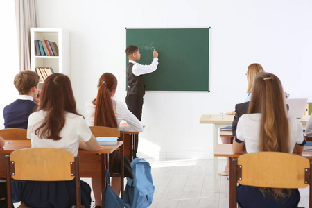 小学生在课堂上回答黑板照片