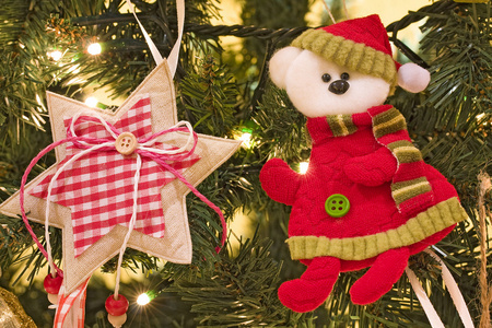 特写的织物装饰物品挂在圣诞树灯都亮着