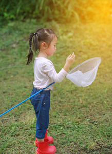 可爱的小亚洲女孩夏天在昆虫网地里戴草帽