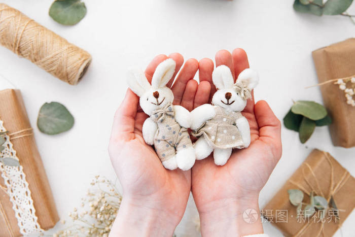 手里捧着两个兔子玩具