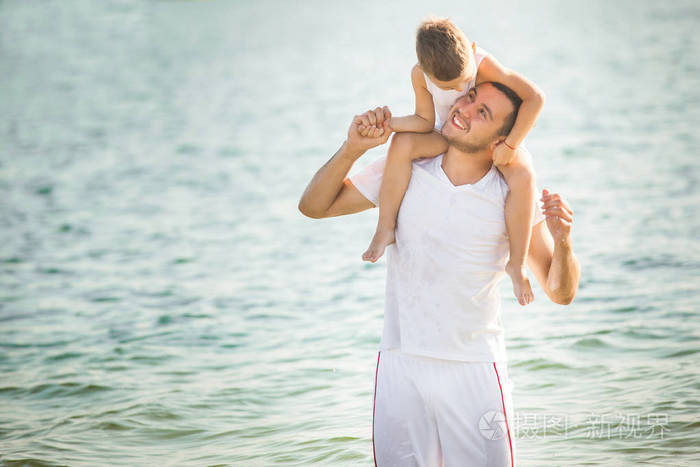 父亲骑儿子在海边的脖子上