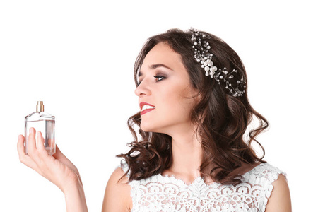 美丽的年轻新娘与香水瓶在白色背景