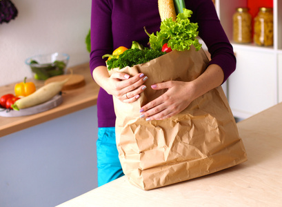 健康积极快乐的女人拿着一个纸袋购物满水果和蔬菜