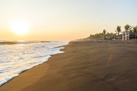 日落在海滩与黑沙子在 Monterrico, 危地马拉