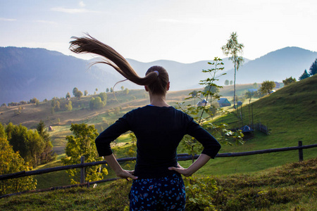 在高山上的旅游妇女与蓝天。在美丽的风景享受自由幸福的妇女。旅游理念