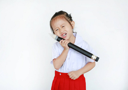 亚洲儿童肖像在学校制服持有大铅笔孤立的白色背景