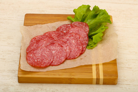 在木背景下的腊肠香肠切片照片