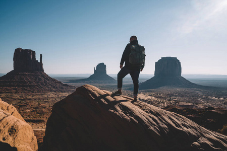 流浪人的剪影与背包享受沙漠砂岩纪念碑的美丽风景, 男性旅行者的背影