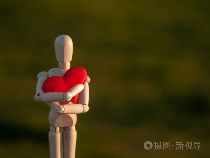 木制模特用双手拥抱他的心浪漫主义与爱情概念