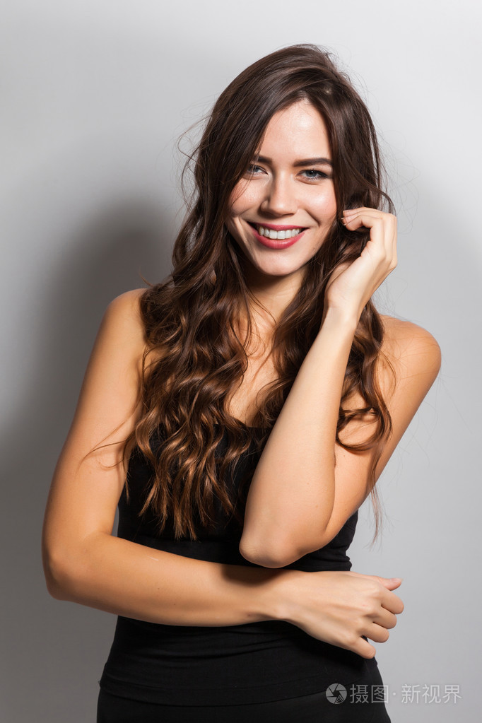 一位身着商务服,面带笑容的黑发女子的商业肖像