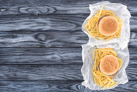 两个汉堡包与薯条在木桌上的最高视图