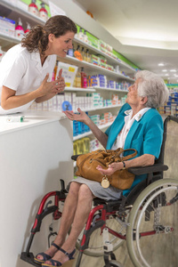 女药剂师在 pharmafy 中对残疾妇女轮椅的服用和解释处方