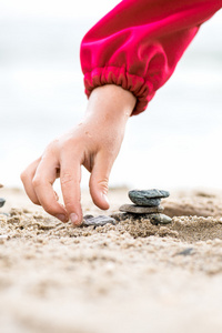 小手放在沙滩上金字塔的石头。Bac 的海