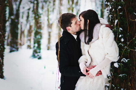 新婚夫妇在冬天逐步森林