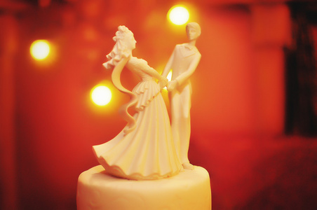 新婚夫妇背景黄色光的小雕像