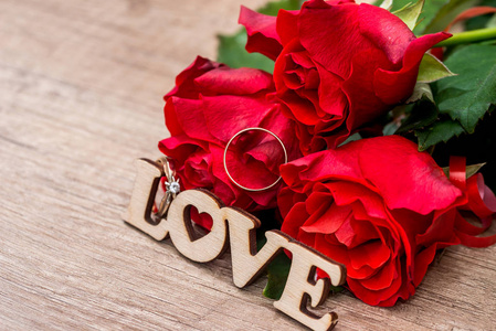 文字爱与结婚戒指, 礼物盒和红色玫瑰照片