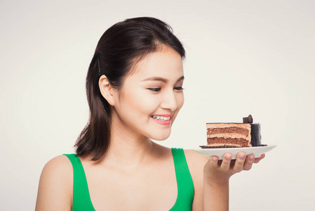 美丽微笑的亚洲年轻女子与孤立的白色背景上的巧克力蛋糕