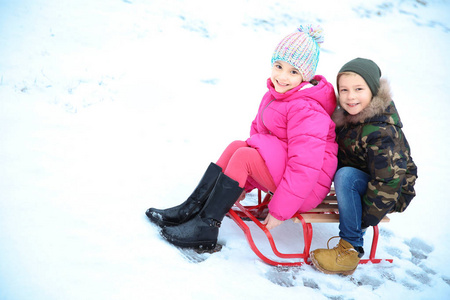可爱的孩子在雪公园雪撬在冬天假期