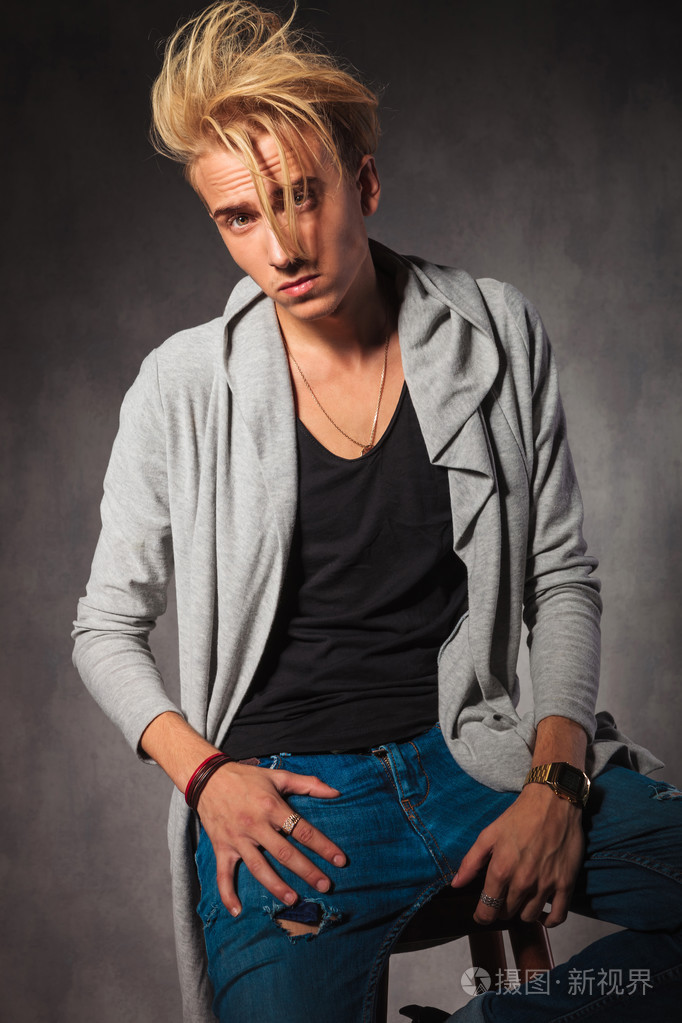 自信的男人凌乱的头发摆在沙发上