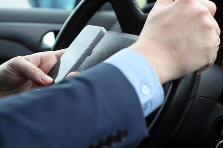 在驾驶汽车时使用智能手机的商人