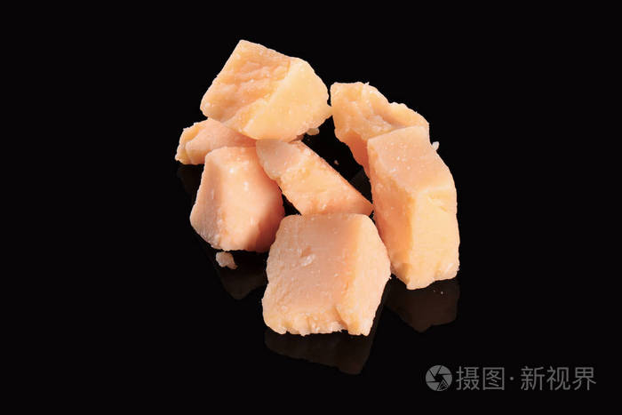 上一个黑色的光泽桌子用反射的干酪黑色背景上孤立的帕玛森芝士