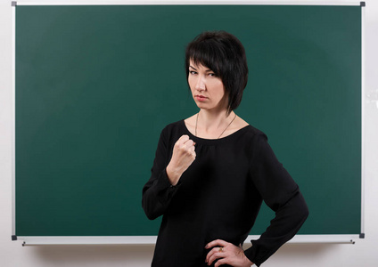严肃的女老师由粉笔板构成, 学习概念, 绿色背景, 演播室射击照片