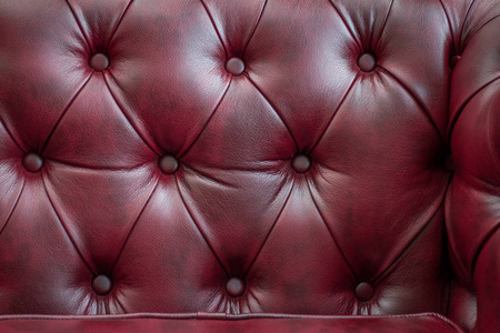特写质地的老式的红色真皮沙发背景