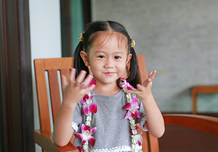 亚洲儿童女孩与欢迎兰花花环