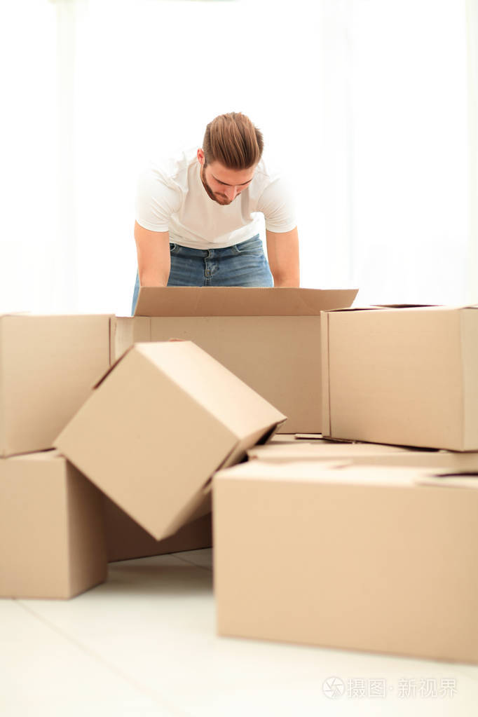 新公寓里的男人整理东西照片-正版商用图片0ngz0w-摄图新视界