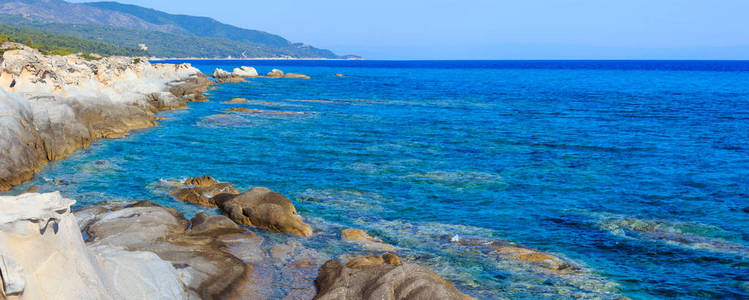 夏季遮阳伞和岩石海岸希腊