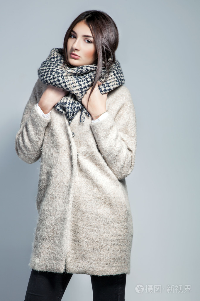 时尚女大衣, 羊毛围巾和帽子摆在工作室在灰色的背景