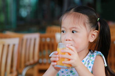 特写的小女孩喝橙汁看出来
