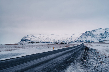 冰岛金色圆路的美丽景色和冬季景观在日落时以雪山为背景, 道路沥青为前景