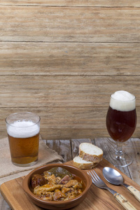 木桌和粘土碗与肉和啤酒眼镜