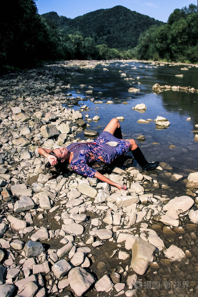 穿橡胶黑色靴子的女士.紫罗兰色的连衣裙