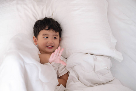 3岁的小可爱亚洲男孩在家里的床上, 孩子躺在