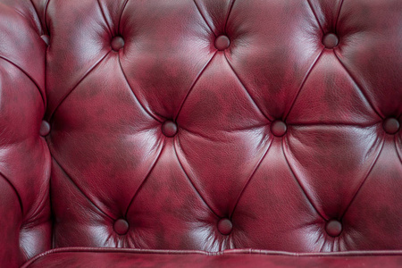 特写质地的老式的红色真皮沙发背景